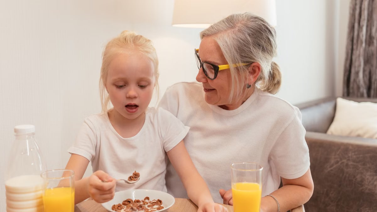 A joyful morning meal shared by a grandmother and granddaughter, showcasing family love.